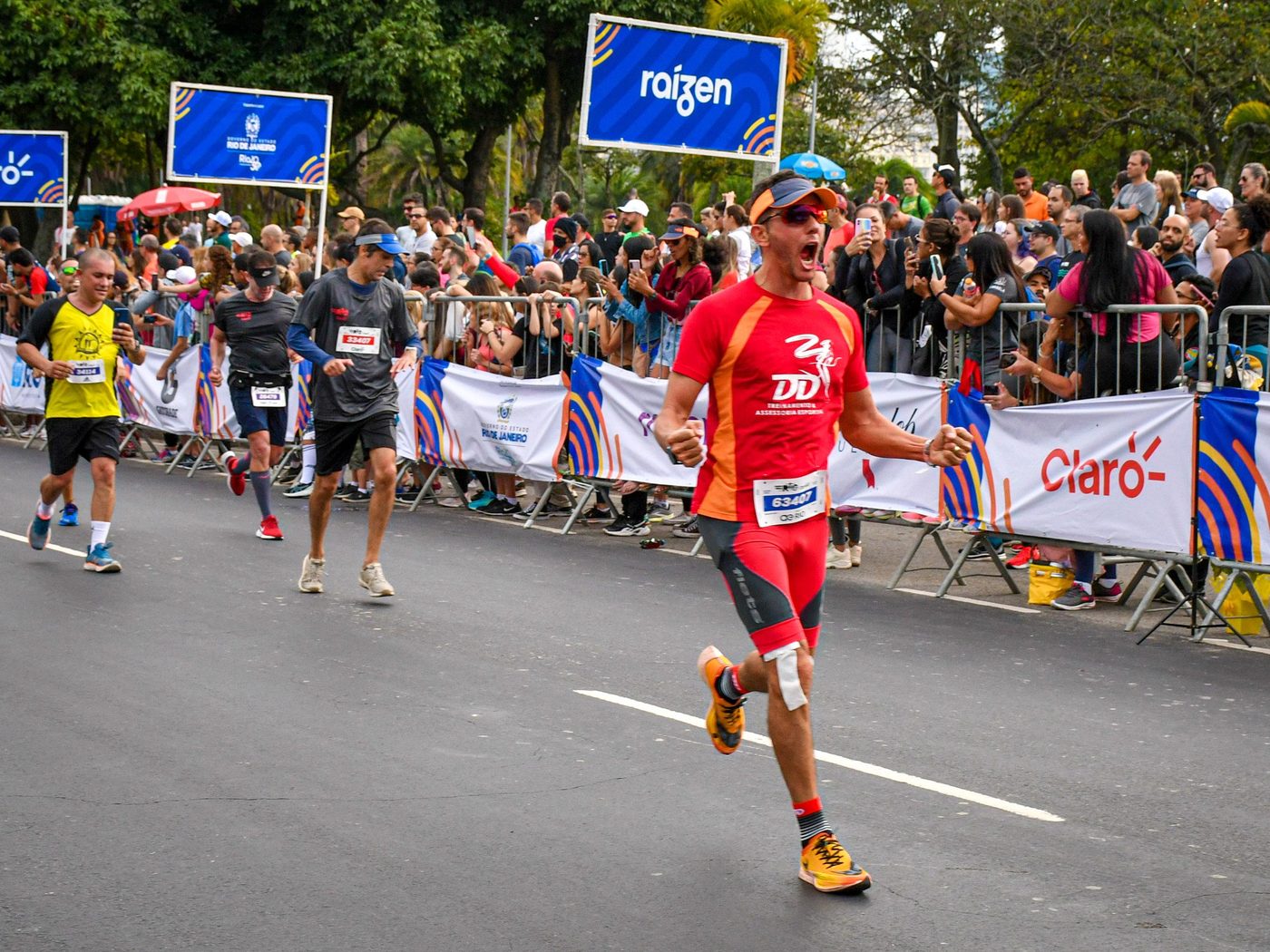 Atleta da DD Treinamento cruzando a linha de chegada com o público na arquibancada